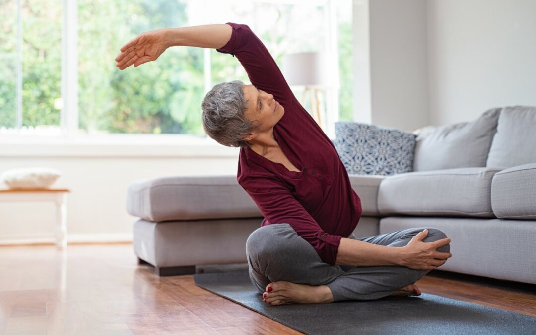 senior woman wearing red doing yoga in her living room