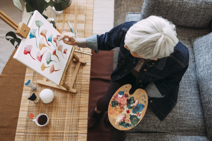 woman painting on a canvas at home