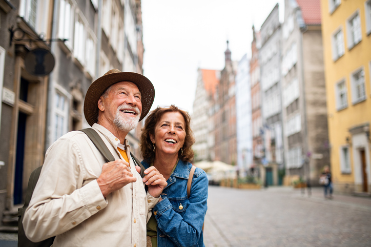 portrait of happy senior couple tourists outdoors in a historic town